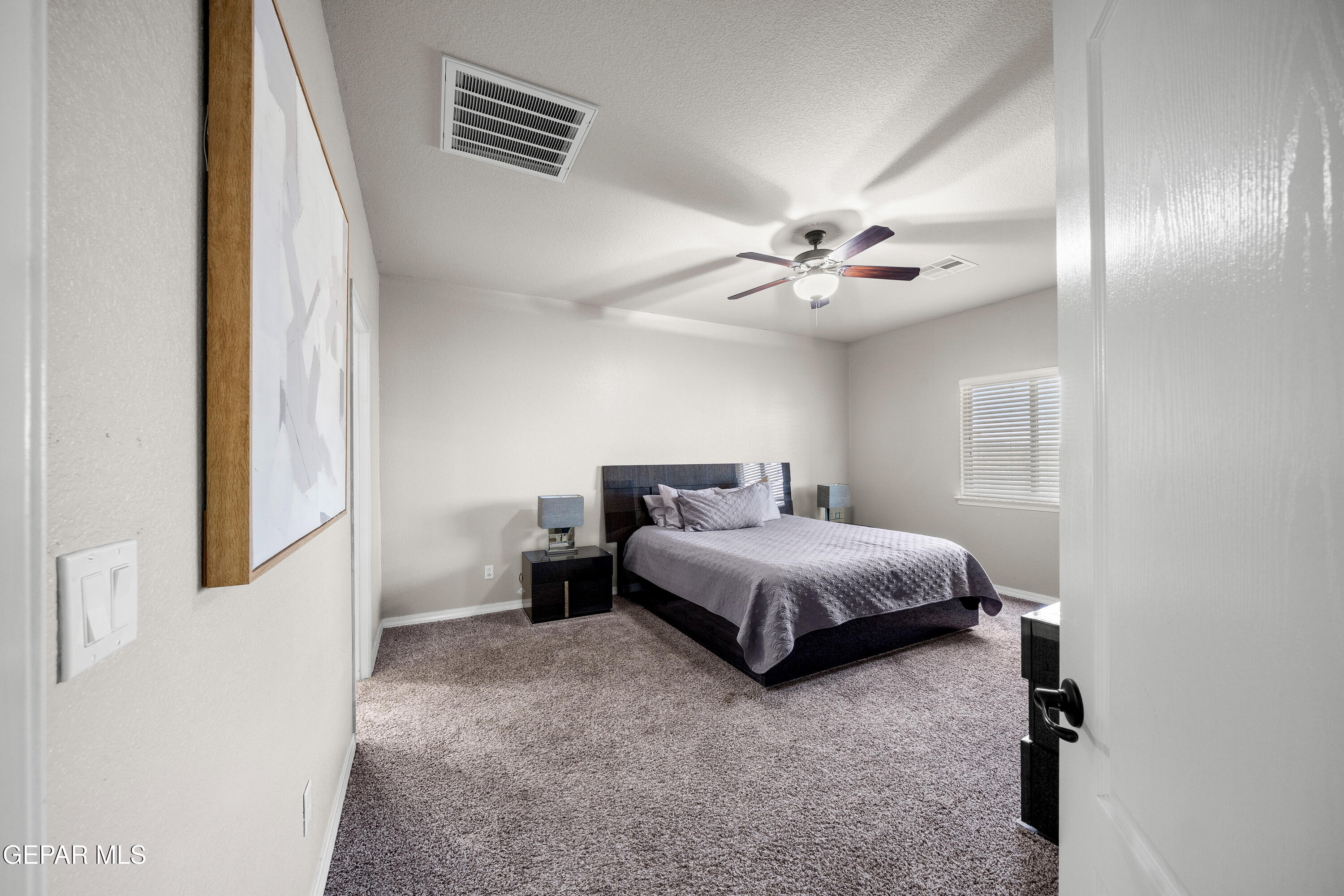 7755 Enchanted Path Drive El Paso, TX 79911 - Photo 11 of 34 a spacious bedroom with a bed and a chandelier