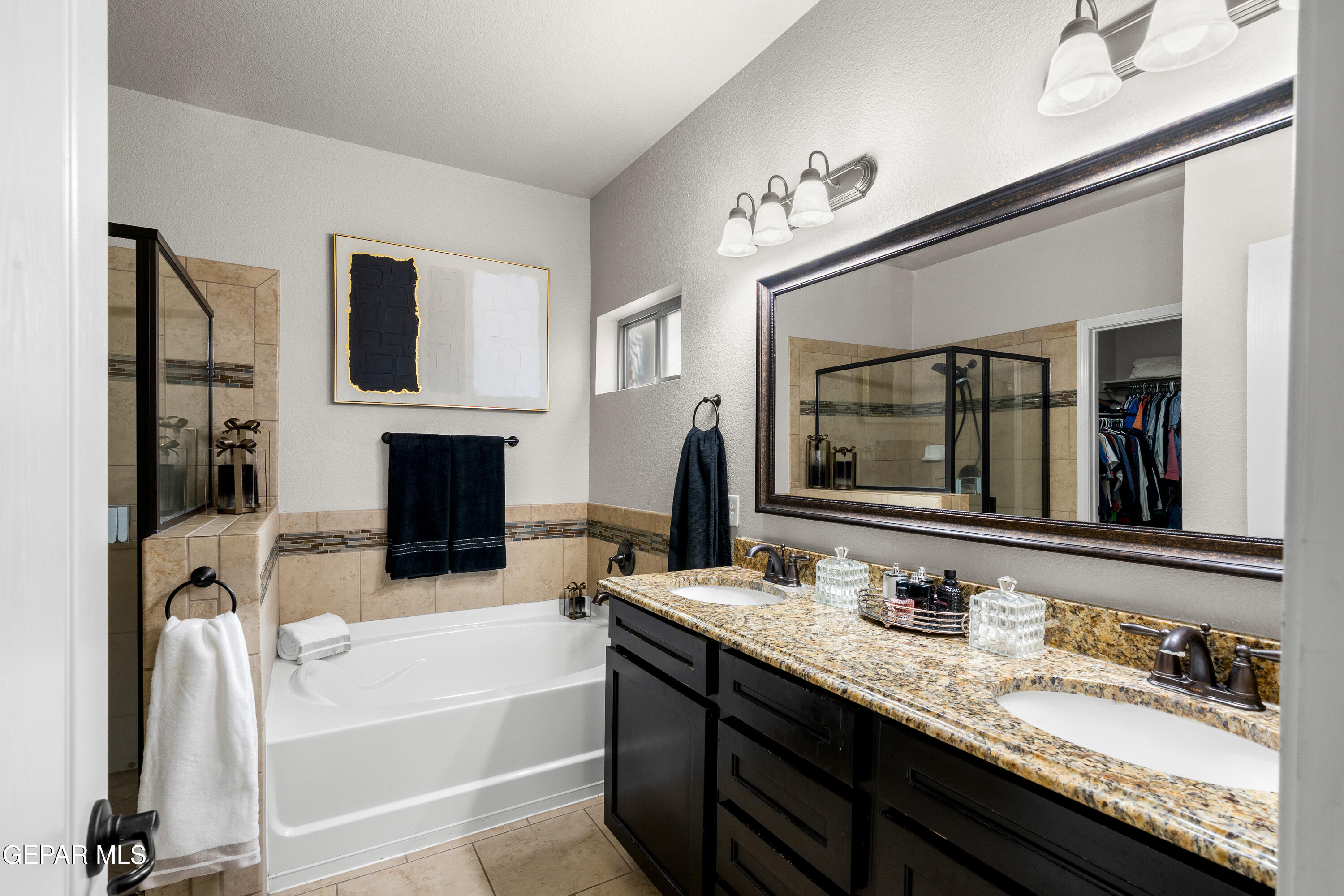 7755 Enchanted Path Drive El Paso, TX 79911 - Photo 13 of 34 a bathroom with a granite countertop double vanity sink a mirror and a bathtub