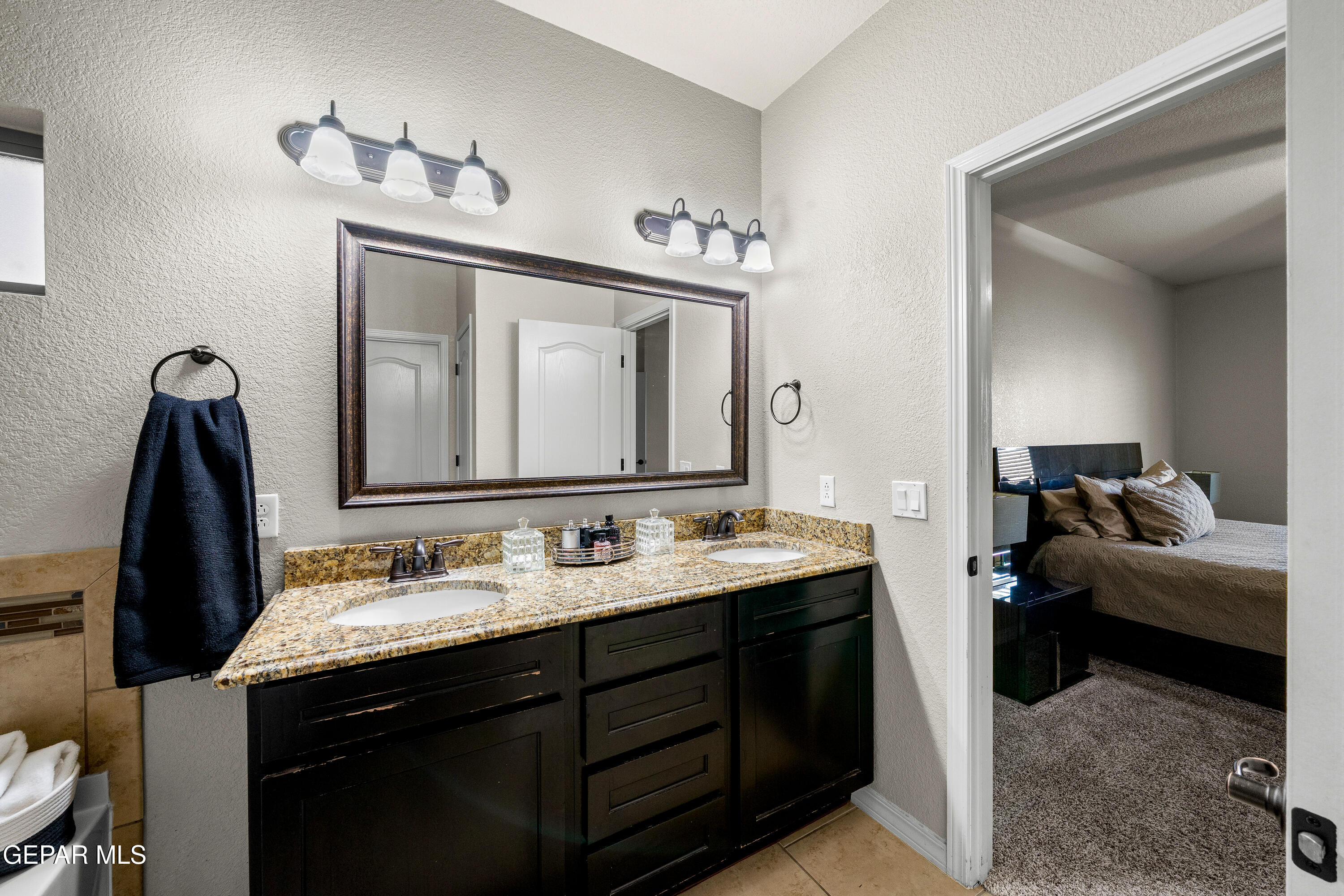 7755 Enchanted Path Drive El Paso, TX 79911 - Photo 14 of 34 a en suite bathroom with a double vanity sink and a mirror