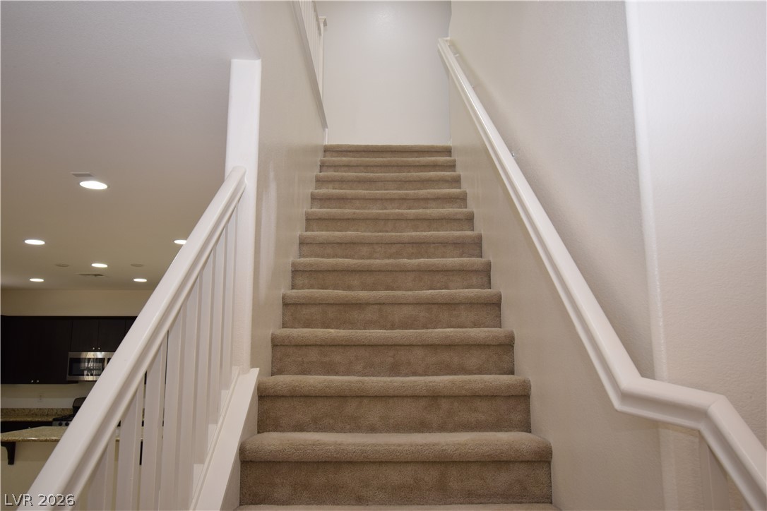 3622 Via Terracina Henderson, NV 89052 - Photo 11 of 22 A graceful carpeted staircase ascends, leading to upper levels with quiet charm.