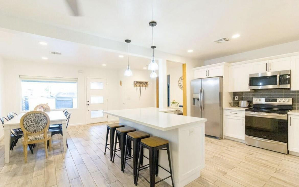 4214 North 20th Street Phoenix, AZ 85016 - Photo 27 of 40 a kitchen with stainless steel appliances granite countertop a stove a refrigerator a kitchen island a dining table and chairs
