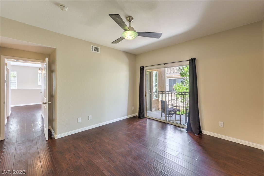 9050 West Warm Springs Road, Unit 2033 Las Vegas, NV 89148 - Photo 18 of 30 Rich hardwood flooring complements the private balcony access in this comfortable room.