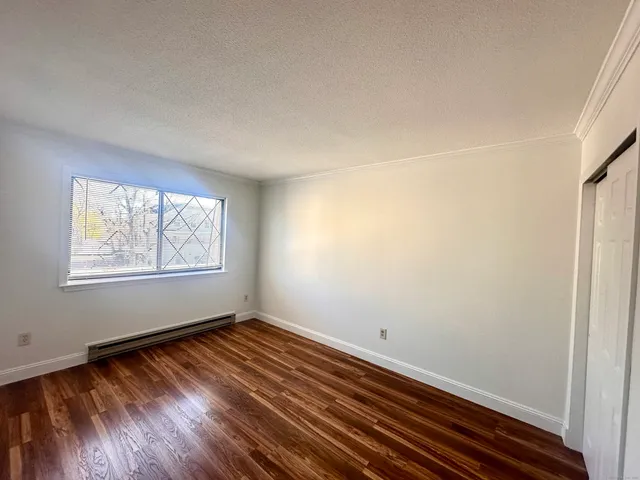 a view of a room with wooden floor and window