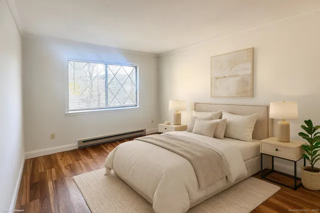 a large bed sitting in a bedroom next to a window