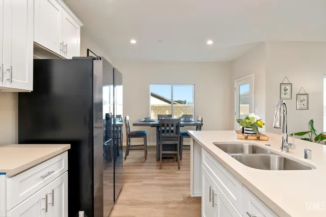 a kitchen with a sink white cabinets and stainless steel appliances