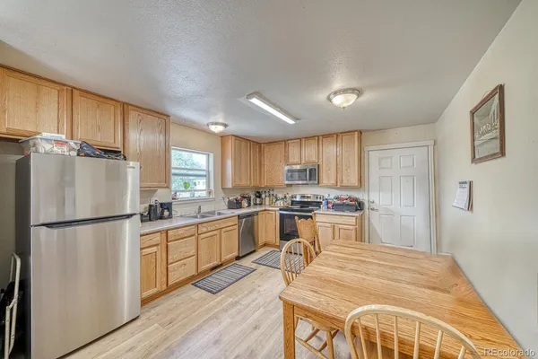 a kitchen with a refrigerator a stove top oven a counter space and wooden floor