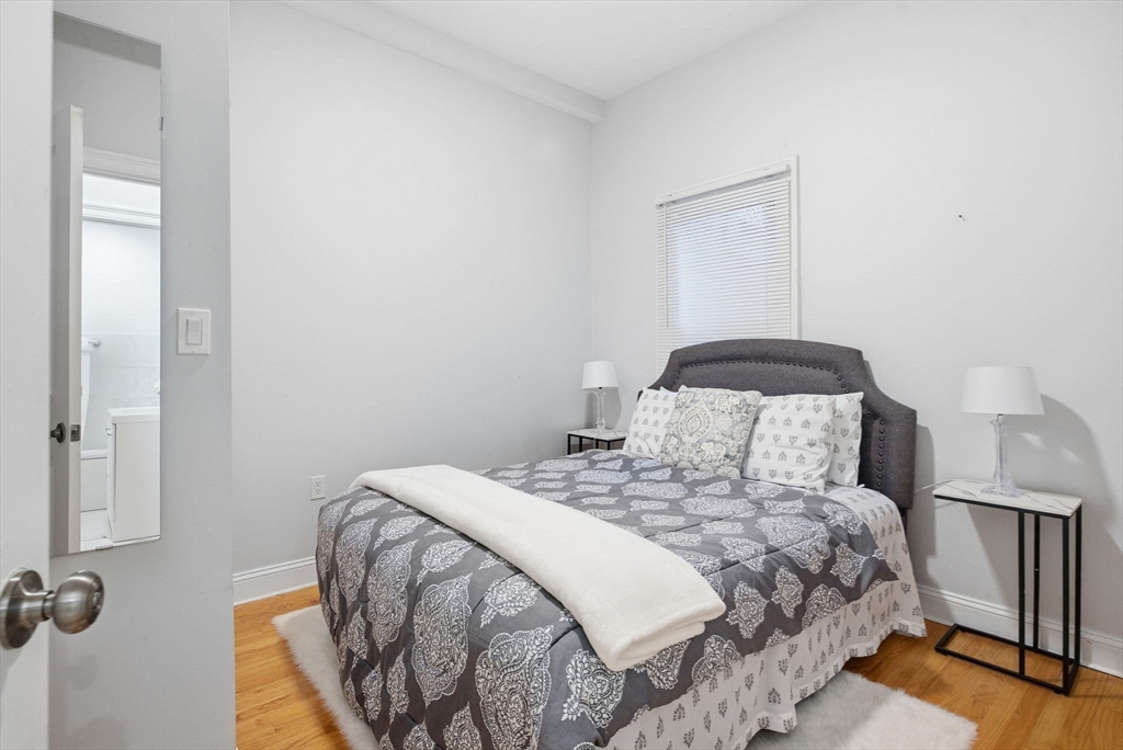80 Marion Street, Unit 2 Boston, MA 02128 - Photo 19 of 33 a bedroom with a bed and wooden floor