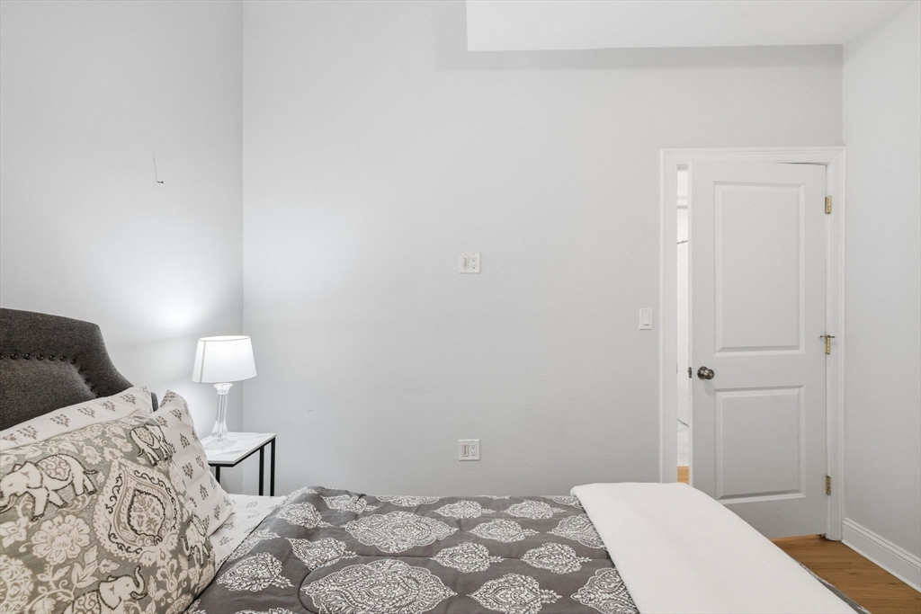 80 Marion Street, Unit 2 Boston, MA 02128 - Photo 20 of 33 a bedroom with a bed and a lamp