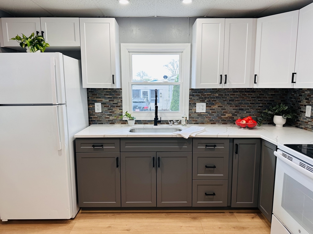 70 Shumway Street, Unit A3 Springfield, MA 01119 - Photo 4 of 28 a kitchen with sink a refrigerator and cabinets