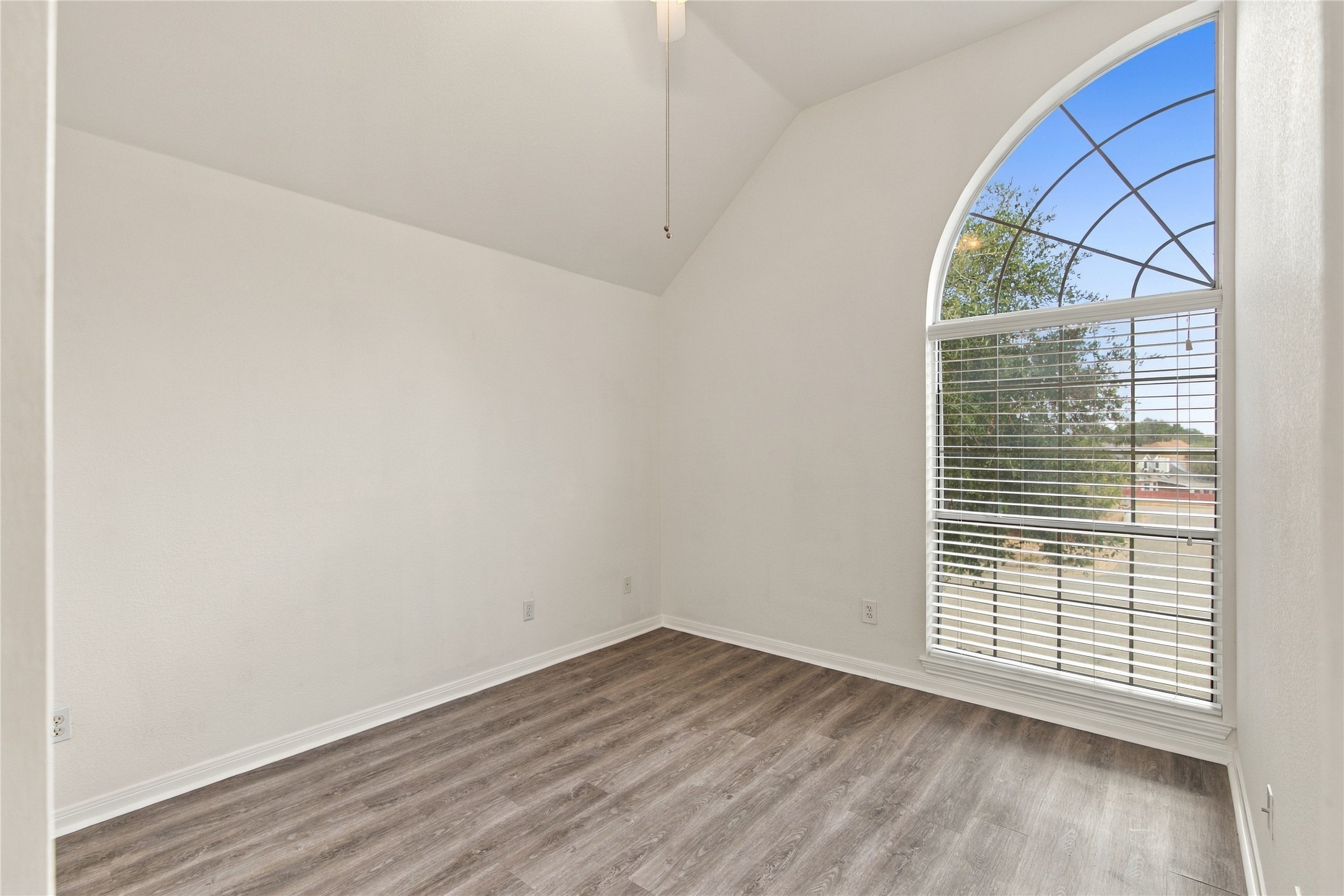 910 Point Run Drive Pflugerville, TX 78660 - Photo 22 of 39 An arched window frames outdoor views in this vaulted room featuring durable wood-look flooring.