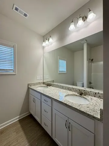 a bathroom with a granite countertop sink double and mirror