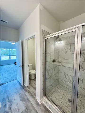 a bathroom with a glass shower door and a toilet