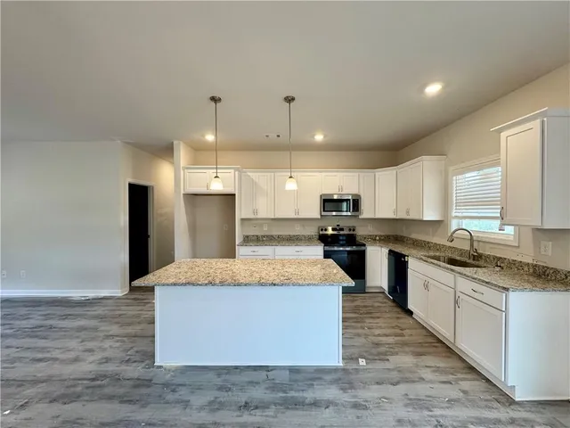 a large kitchen with kitchen island a counter top and stainless steel appliances