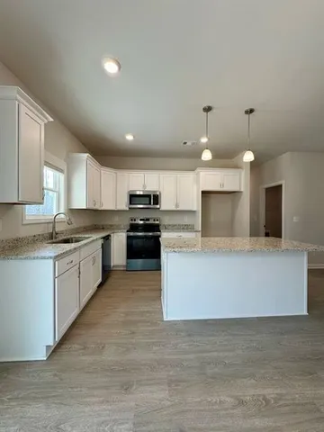 a large kitchen with a large counter top and stainless steel appliances