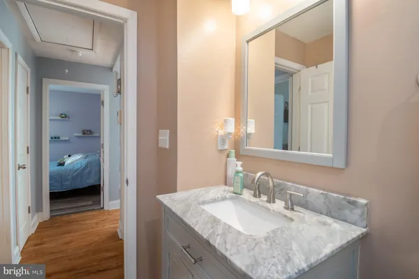 a en suite bathroom with a granite countertop sink and a mirror