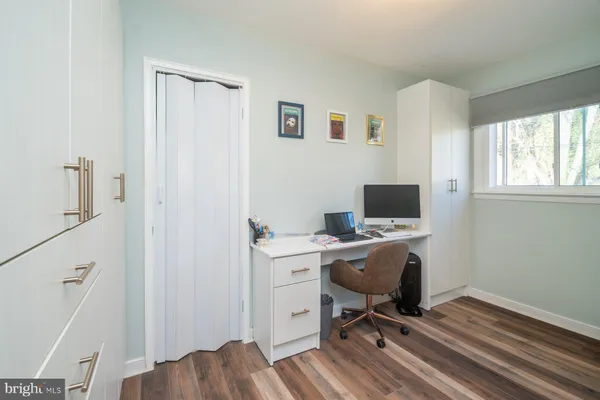 a view of a workspace with furniture and a window