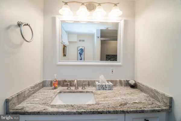 a bathroom with a granite countertop sink and a mirror