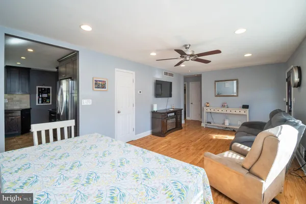 a living room with furniture kitchen view and a flat screen tv