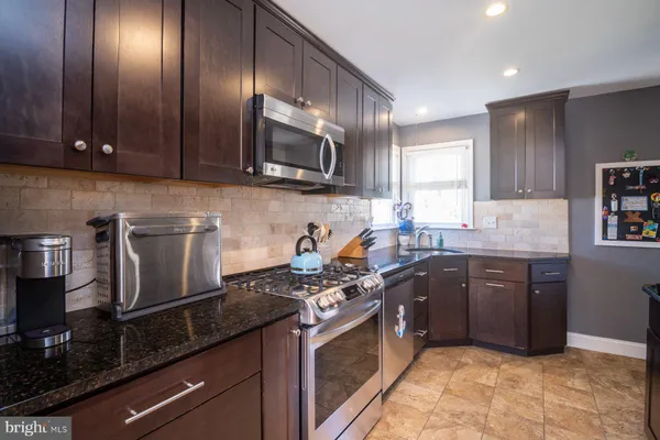 a kitchen with stainless steel appliances granite countertop a sink stove and microwave