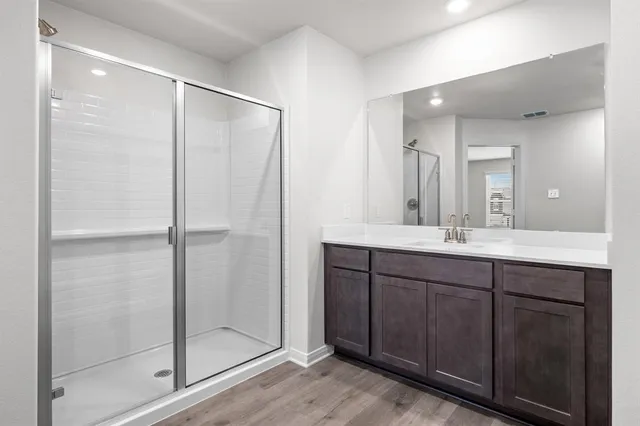a bathroom with a double vanity sink mirror and shower