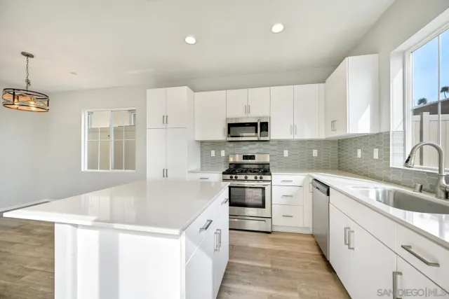 a kitchen with granite countertop white cabinets and white appliances