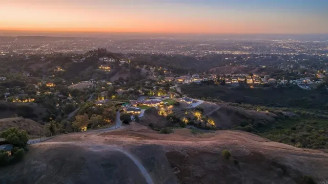 an aerial view of house with yard and mountain view in back