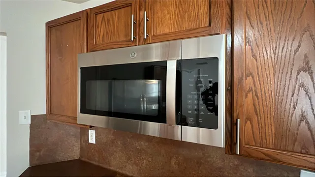 a kitchen with granite countertop white cabinets and stainless steel appliances