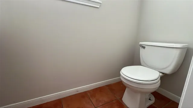 a white toilet sitting next to a white wall