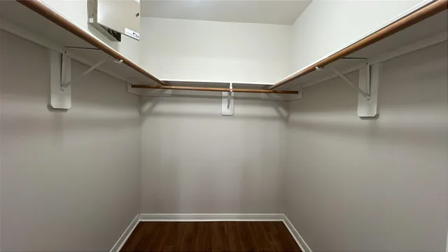 a view of walk in closet with empty racks