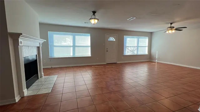 an empty room with windows and a fireplace