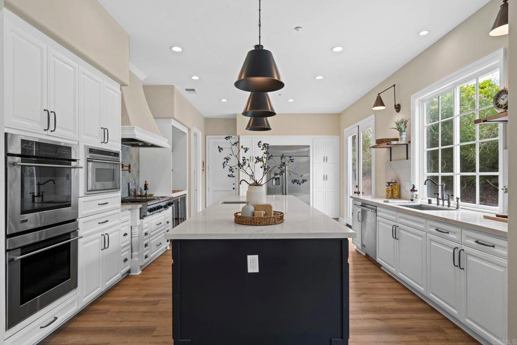 707 Olympus Street Encinitas, CA 92024 - Photo 12 of 47 a kitchen with stainless steel appliances granite countertop a sink a stove and a wooden floors