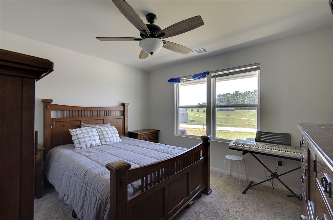 408 Chadwick Lane Walhalla, SC 29691 - Photo 18 of 44 A restful chamber offers serene outdoor views through large windows, complemented by a contemporary ceiling fan.
