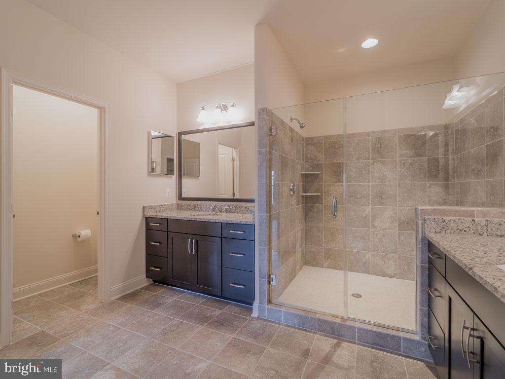 22595 Windsor Locks Square Ashburn, VA 20148 - Photo 38 of 56 a bathroom with a granite countertop sink a mirror and a bathtub