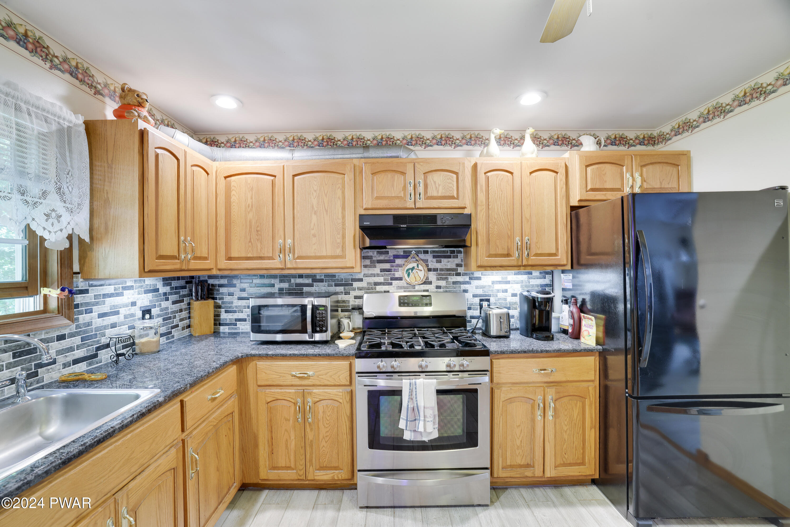 134 Magic Mountain Road Henryville, PA 18332 - Photo 26 of 62 a kitchen with stainless steel appliances granite countertop a refrigerator sink and stove