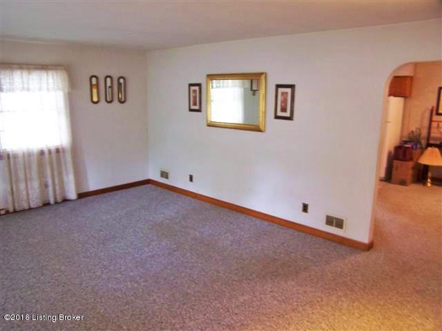 4604 Dover Road Louisville, KY 40216 - Photo 21 of 37 Living Room with an entry closet, carpeting with hardwood flooring underneath, 3 windows plus on large picture window, arched doorway to the Dining Area and plenty of room to entertain.