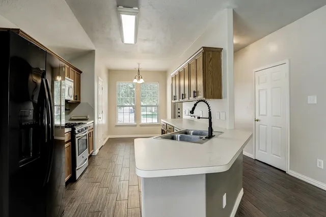 a kitchen with kitchen island a sink appliances and cabinets
