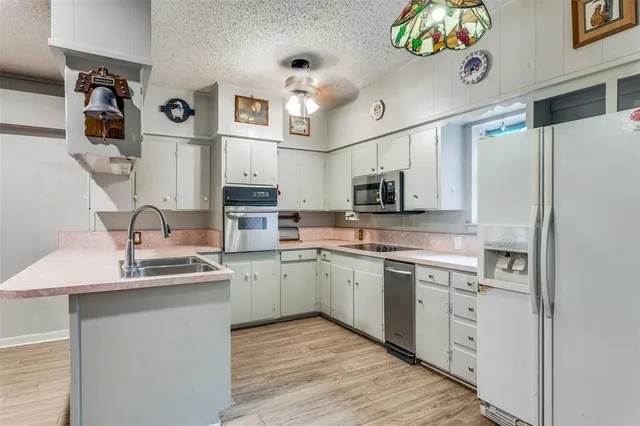 a kitchen with stainless steel appliances granite countertop a sink and dishwasher a refrigerator with wooden floor