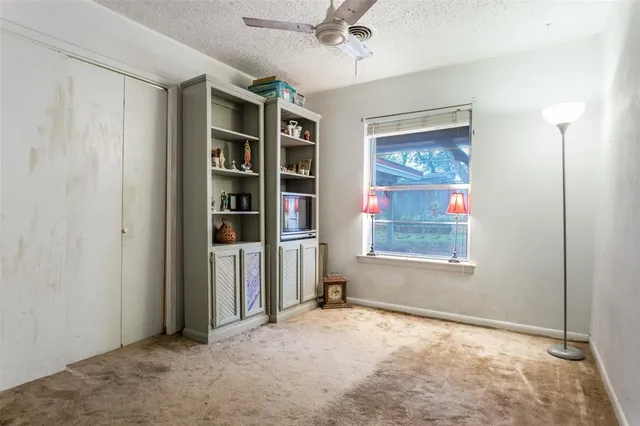 an empty room with closet and windows