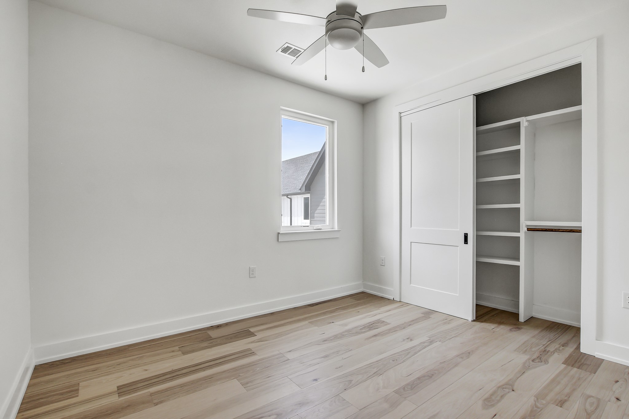 4127 East 12th Street, Unit 4 Austin, TX 78721 - Photo 23 of 32 Unfurnished bedroom with light wood-style flooring, baseboards, a closet, and a ceiling fan