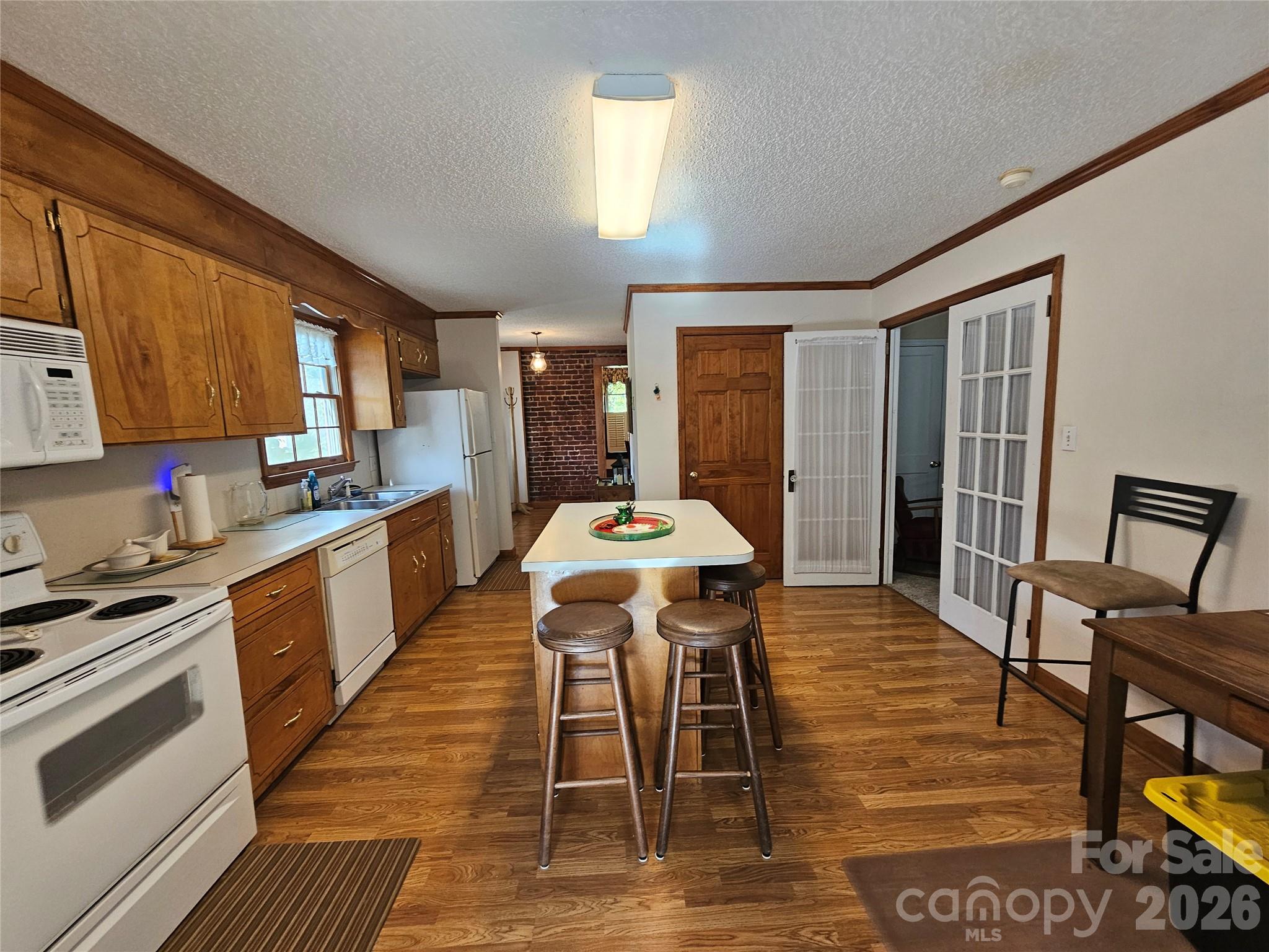 711 Chesterfield Avenue Lancaster, SC 29720 - Photo 19 of 19 a kitchen with stainless steel appliances kitchen island granite countertop a stove a sink a dining table and chairs with wooden floor