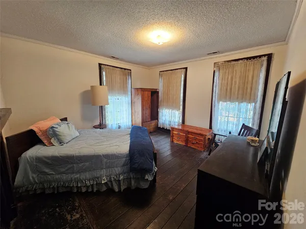 a bedroom with a bed and large windows