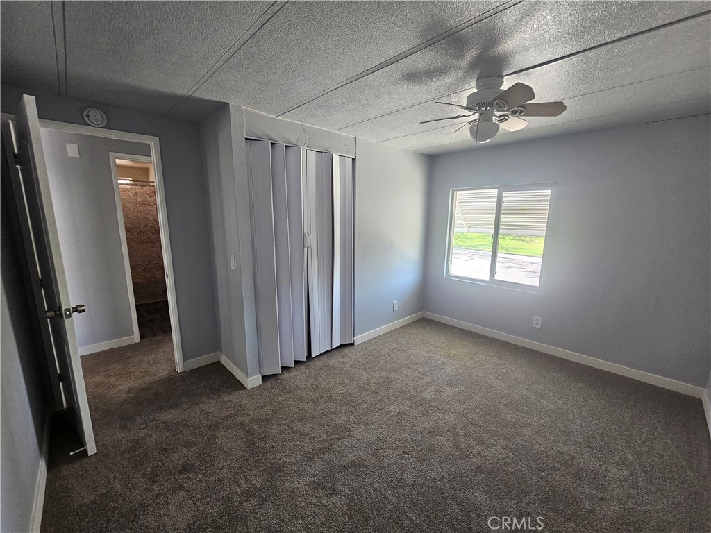 1721 East Colton Avenue, Unit 33 Redlands, CA 92374 - Photo 12 of 17 an empty room with windows closet and chandelier fan