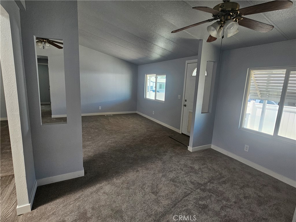 1721 East Colton Avenue, Unit 33 Redlands, CA 92374 - Photo 6 of 17 an empty room with chandelier fan and windows