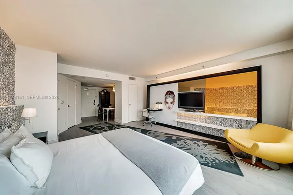 a bedroom with a bed and a flat screen tv