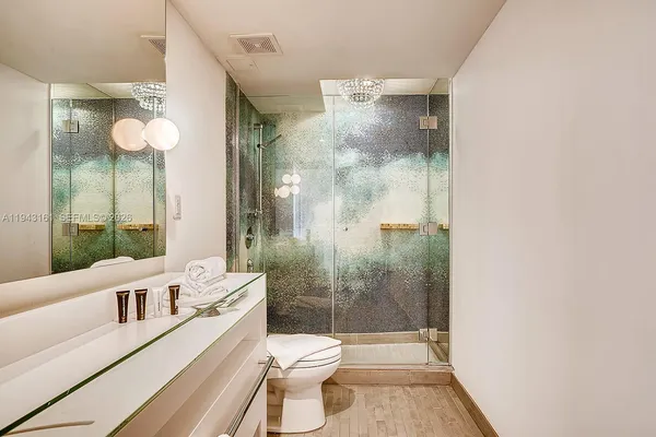 a bathroom with a bathtub shower sink mirror and toilet
