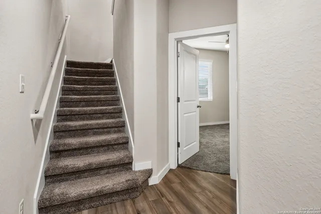 a view of a hallway with wooden floor and entryway