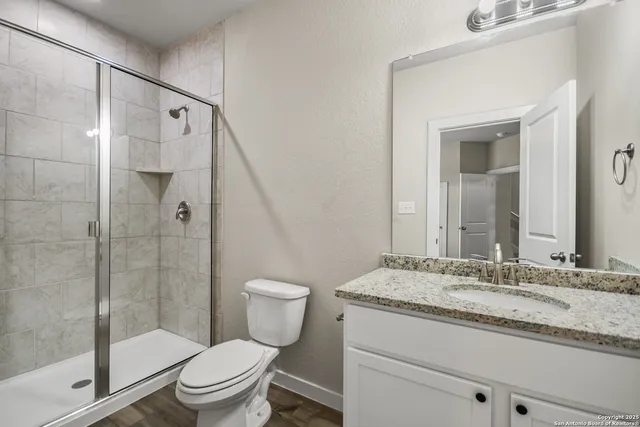 a bathroom with a granite countertop sink toilet and shower