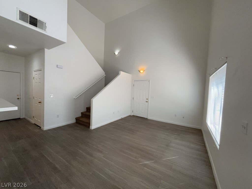 4915 East Russell Road, Unit 159 Las Vegas, NV 89120 - Photo 2 of 12 Unfurnished living room featuring a high ceiling and dark wood-style floors