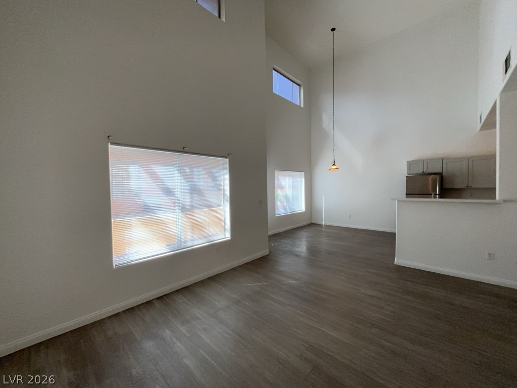 4915 East Russell Road, Unit 159 Las Vegas, NV 89120 - Photo 3 of 12 Unfurnished living room featuring dark wood-style floors and a high ceiling