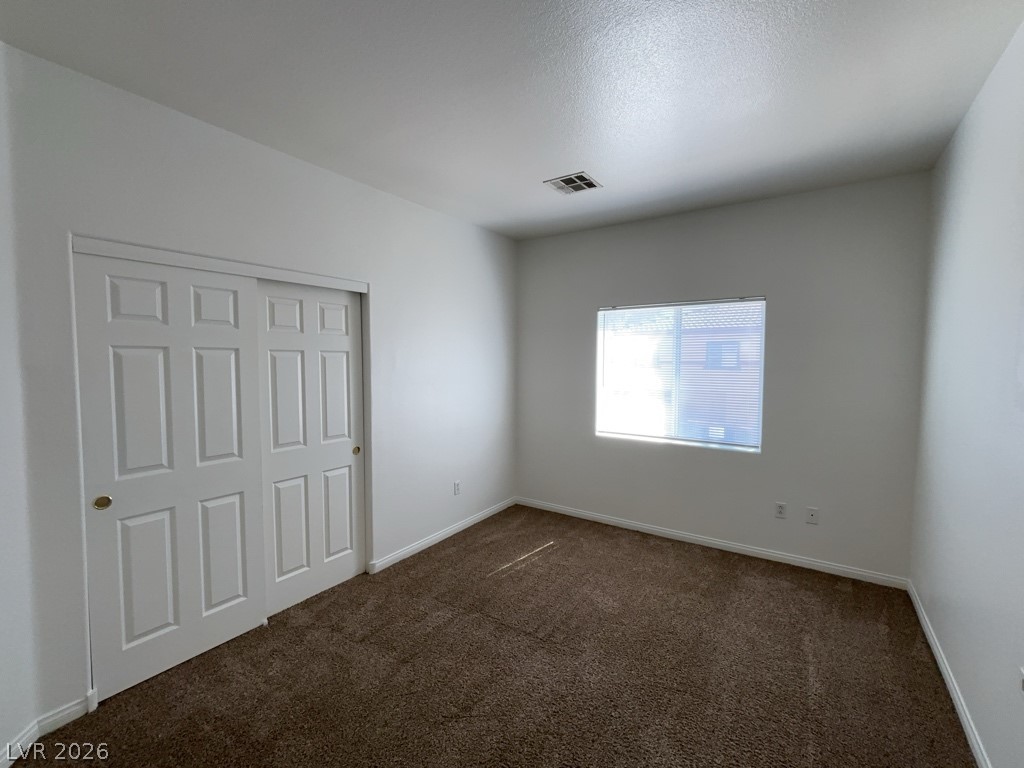 4915 East Russell Road, Unit 159 Las Vegas, NV 89120 - Photo 6 of 12 Unfurnished bedroom with a closet and dark carpet